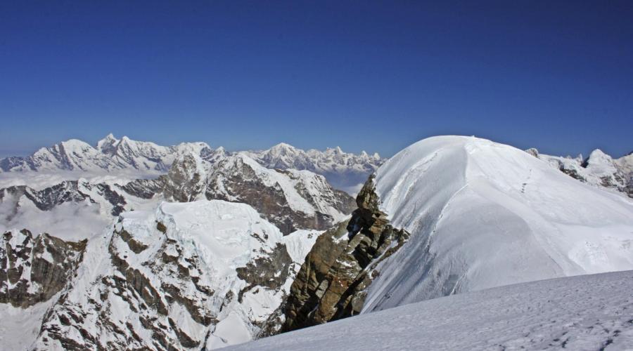 Hinter dem Gipfelplateau des Mera Peak reihen sich die hohen Berge des Himalaya.